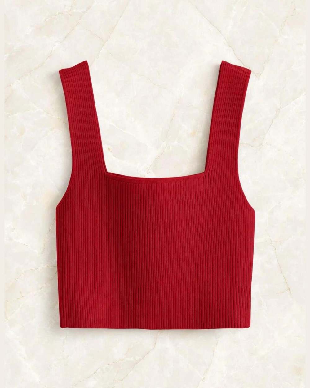 Blusa roja de tirantes acanalada, aislada (gancho eliminado) sobre mármol marfil