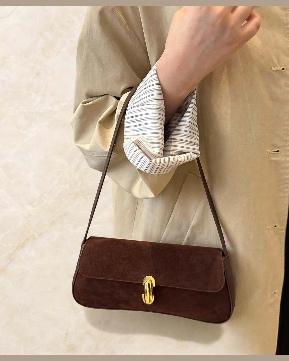 Cartera marrón tipo baguette de gamuza con hebilla dorada