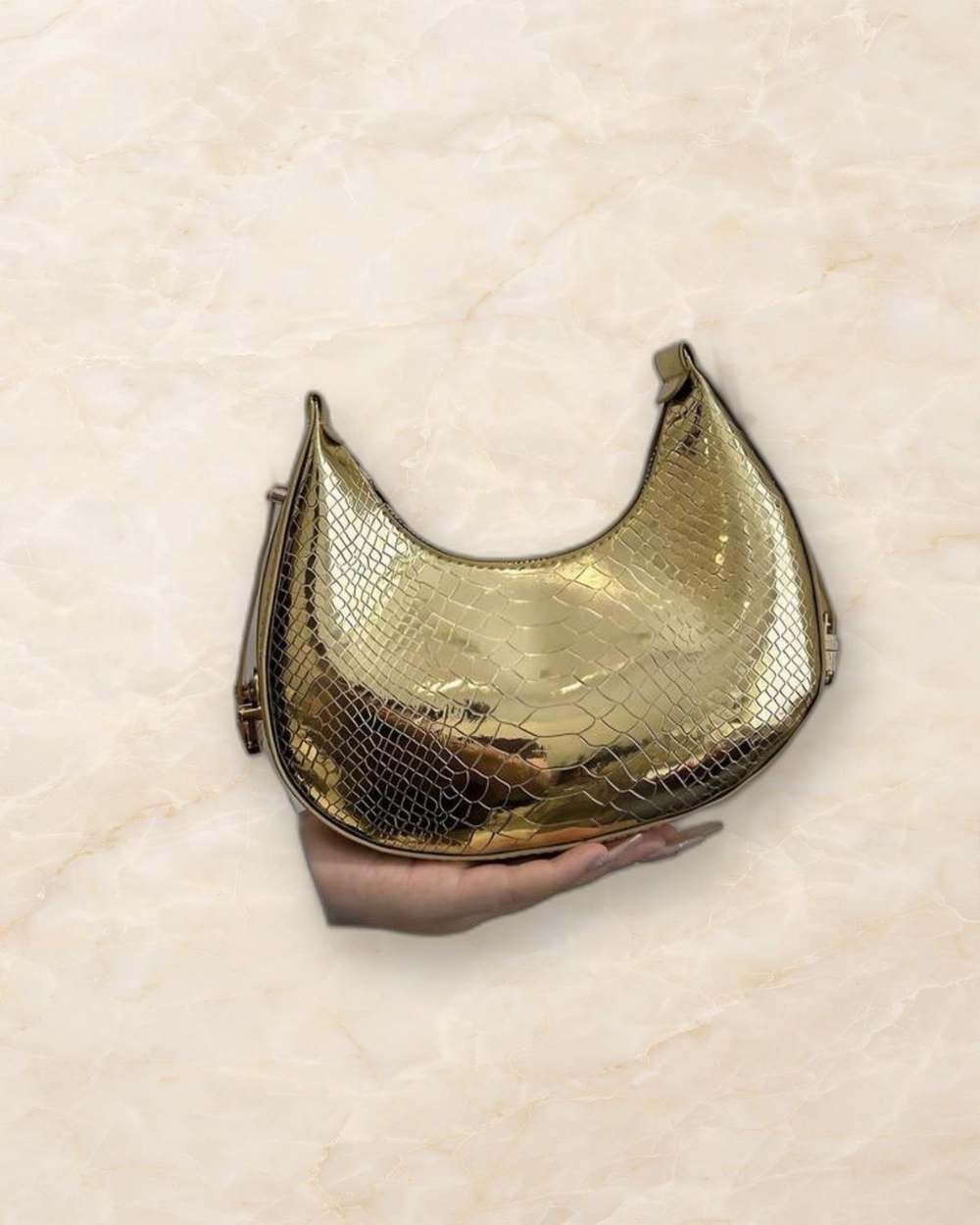 Cartera hobo dorada con textura de serpiente