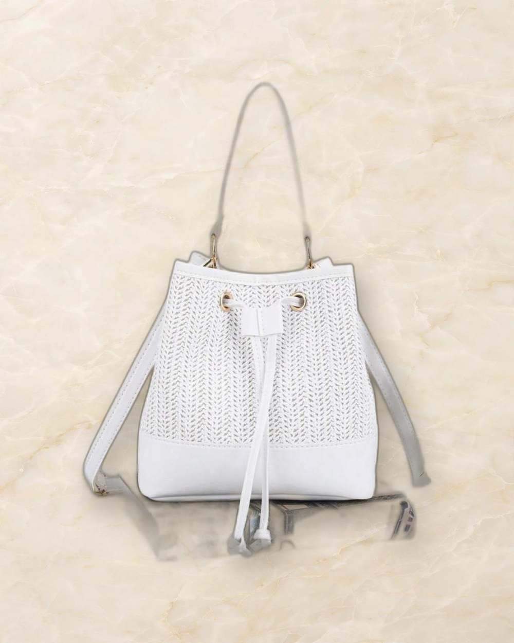Cartera blanca tipo bucket., aislado sobre mármol marfil