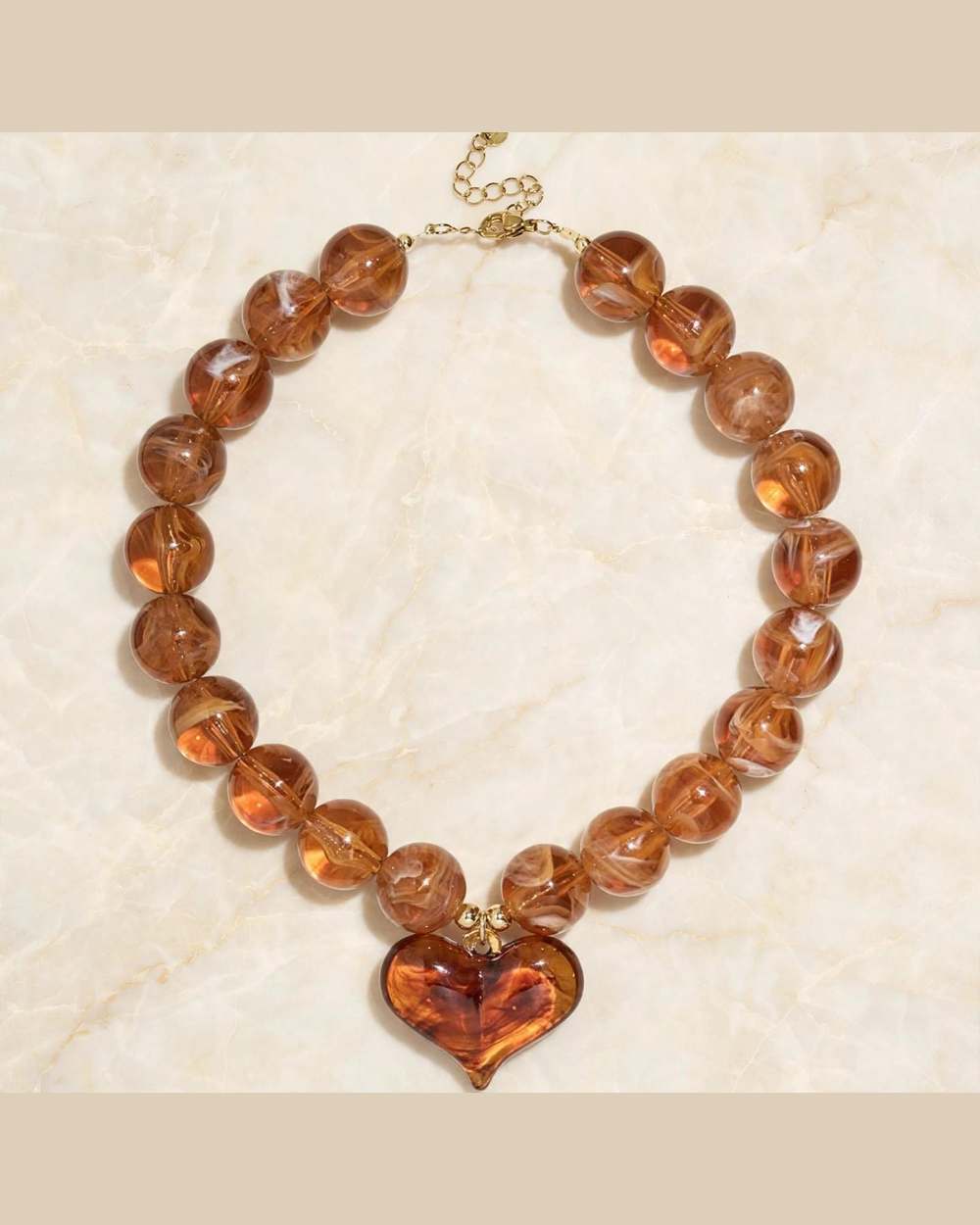 Collar de bolas ámbar con dije de corazón en tonos caramelo
