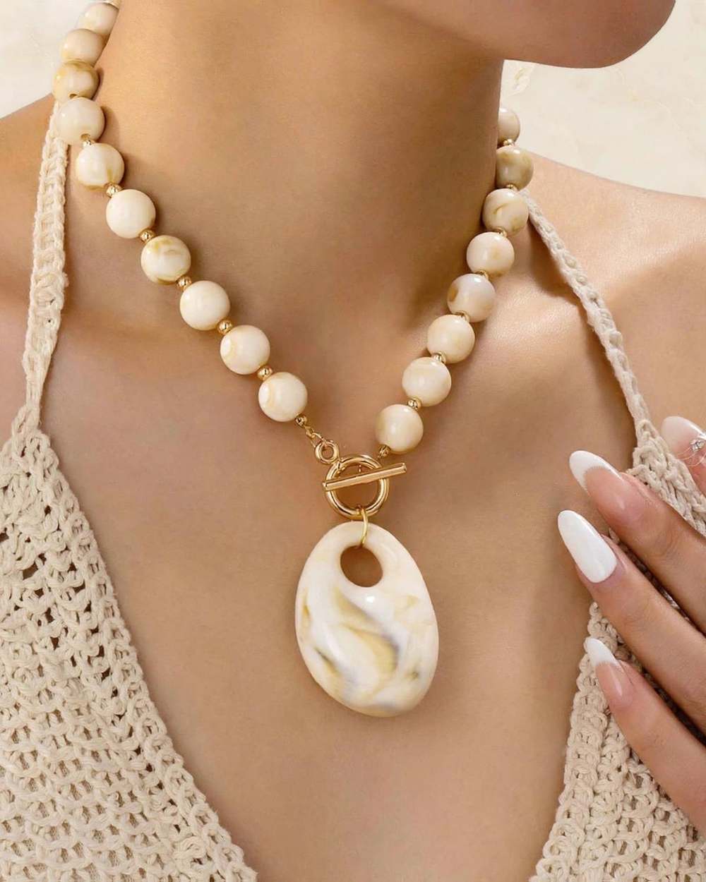 Collar marmol dije ovalado, aislado sobre mármol marfil