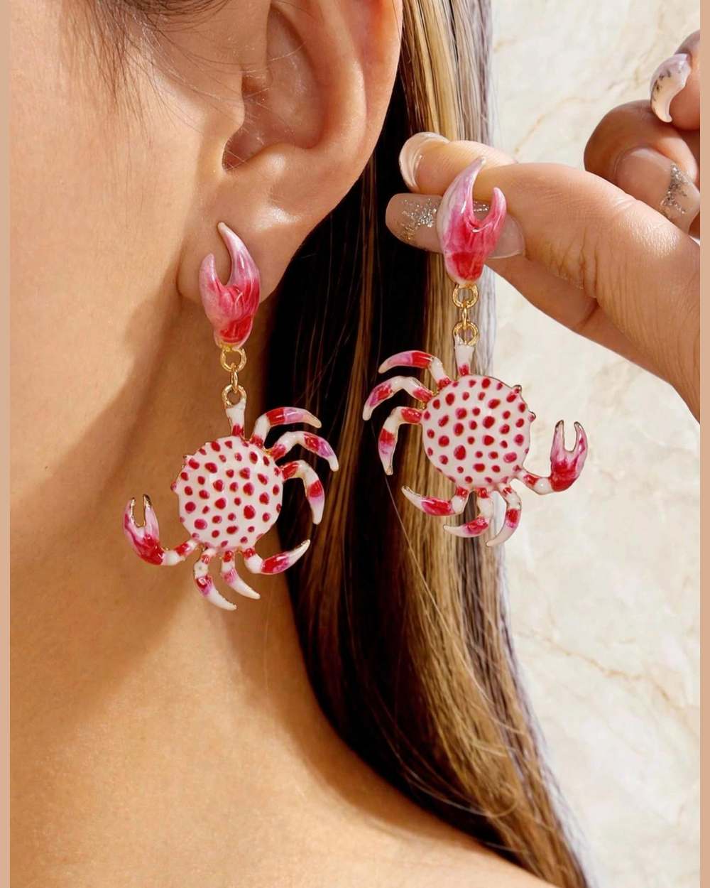 Modelo con zarcillos de cangrejo blanco con puntos rojos